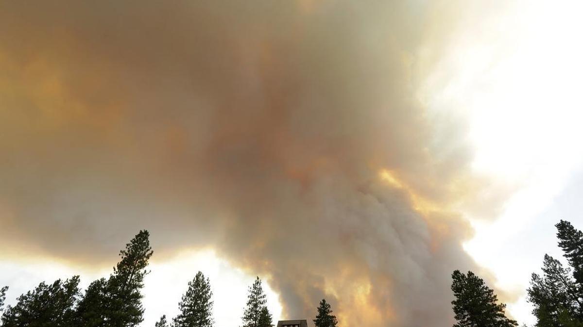 
Smoke from an approaching wildfire looms over a home near Twisp, Wash., Wednesday, Aug. 19, 2015. Authorities on Wednesday afternoon urged people in the north-central Washington town to evacuate because of a fast-moving wildfire.
