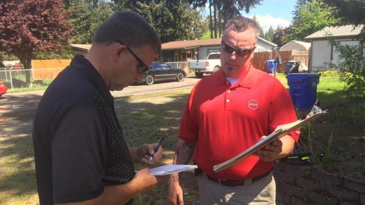 Detective Ben Benson and Deputy Fire Marshal Chris Lyman work at the scene of a fatal house fire Monday.