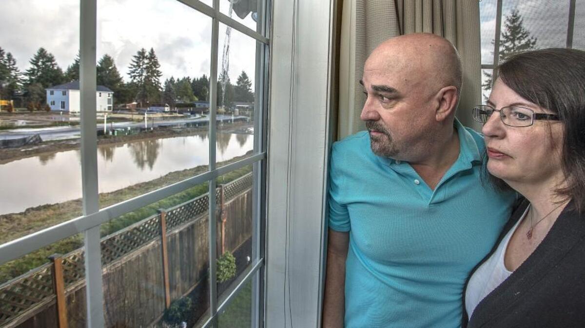 Dave and Anne Ellison have watched a “lake” grow in the housing development directly behind their University Place home as a developer attempts to build 21 homes on the property. The underground springs have been disrupted and are flowing into their crawlspace, burning out their residential sump pump and requiring the Ellisons to buy an industrial-grade pump. They question how the city could allow development on a known wet area.