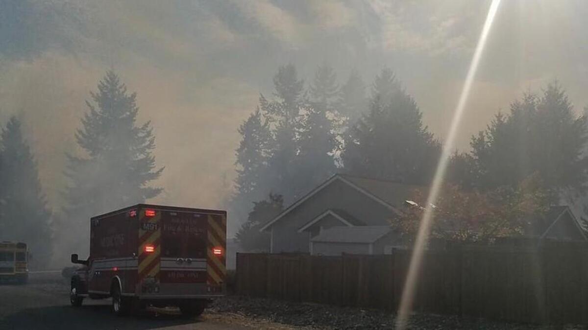 Firefighters respond to a three-alarm brush fire in Graham on Friday afternoon.