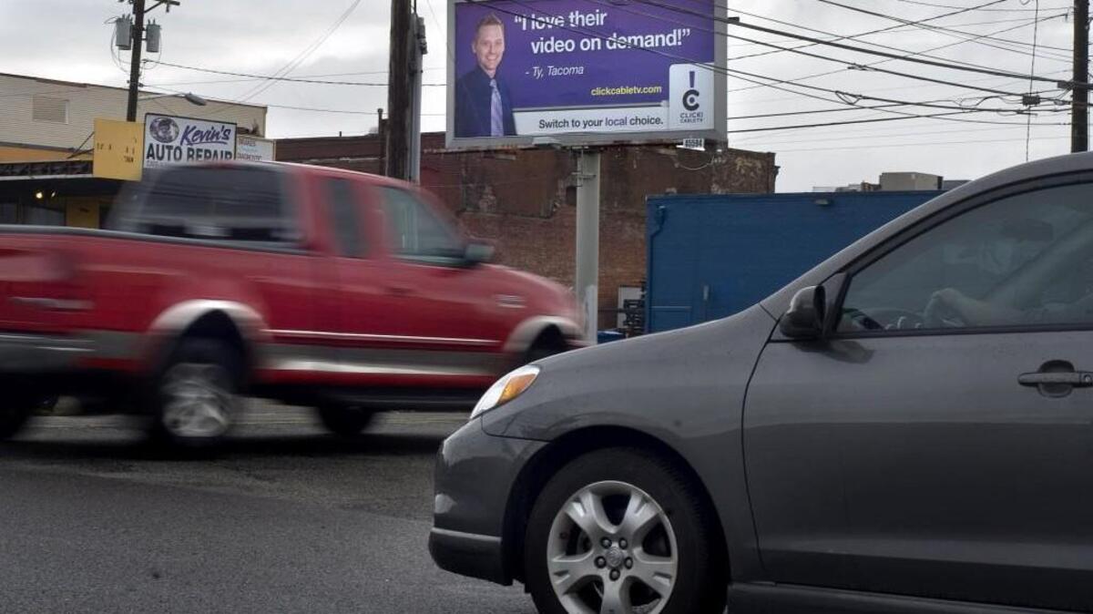 Traffic passes in front of a Click! billboard near the intersection of South L Street and Earnest S. Brazil Street in Tacoma on May 23, 2012. The Tacoma City Council approved a settlement agreement with advertising giant Lamar Tuesday, Dec., 12, that will regulate billboards within the city.