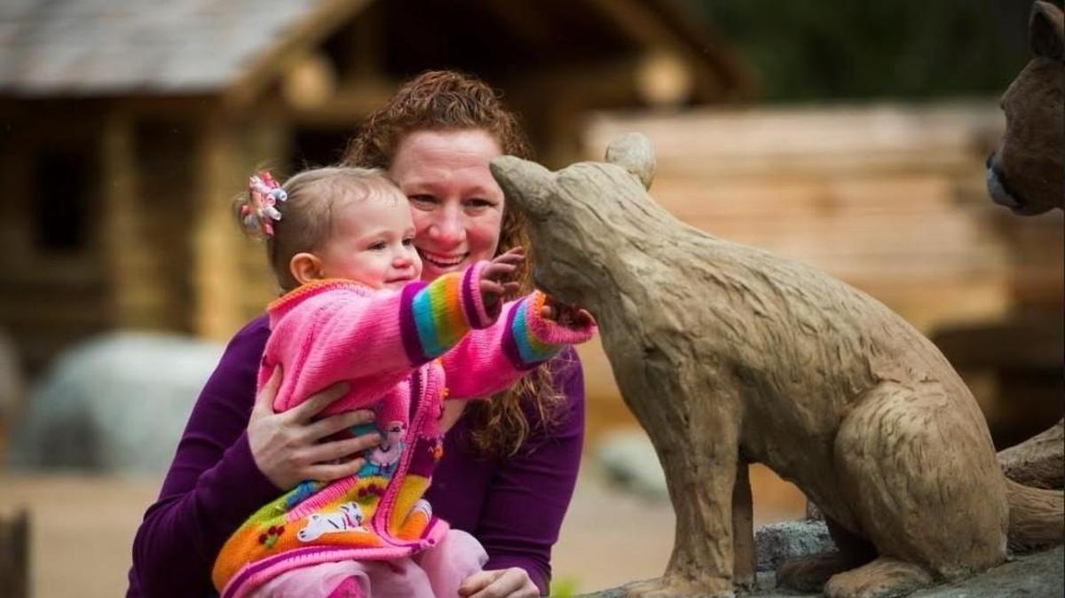 A toddler gets up close to a replica cougar cub in the Kids’ Trek nature-inspired play area at Northwest Trek Wildlife Park.