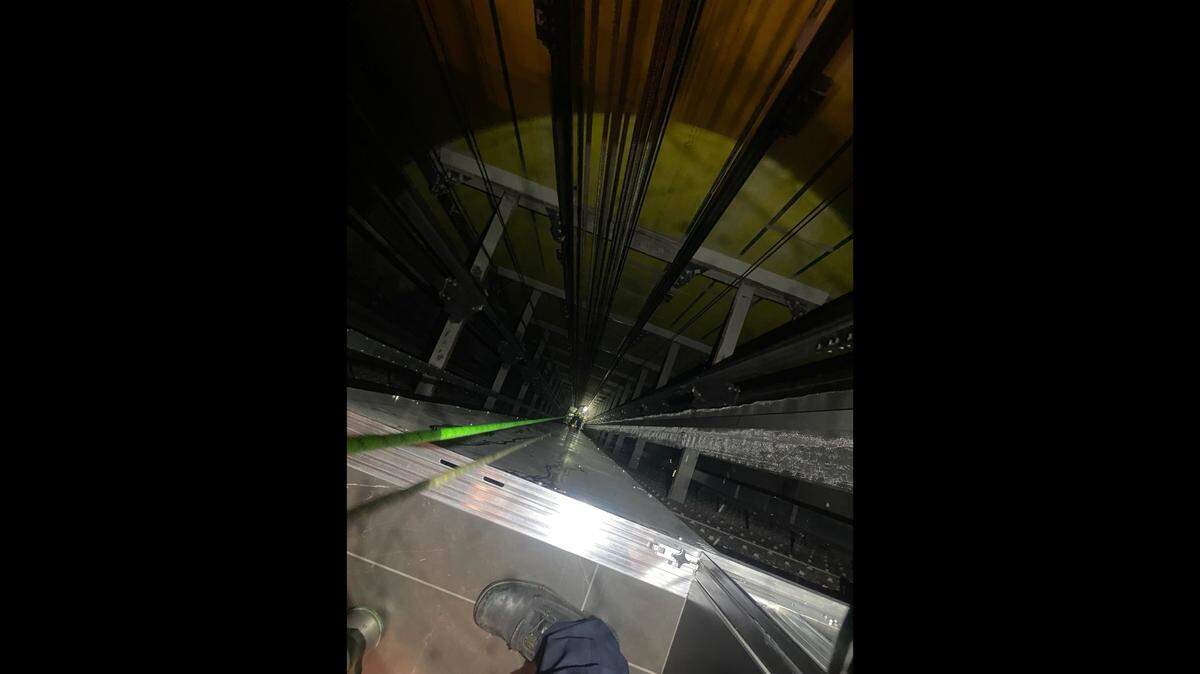Firefighters rappelled hundreds of feet down an elevator shaft at a high-rise apartment to help people stuck in an elevator.