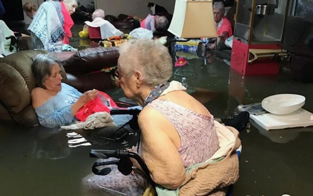 In this Sunday, Aug. 27, 2017, photo provided by Trudy Lampson, residents of the La Vita Bella nursing home in Dickinson, Texas, sit in waist-deep flood waters caused by Hurricane Harvey. Authorities said all the residents were safely evacuated from the facility.