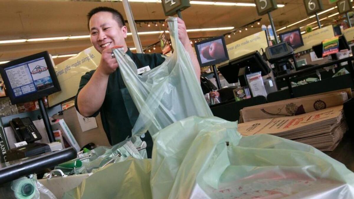 Will Gong bags up groceries for customers at Ralph’s Thriftway in Olympia in 2012. Olympia has since banned plastic bags. The city of Gig Harbor is considering similar ordinances that would ban certain types of plastic bags, to-go containers and straws.