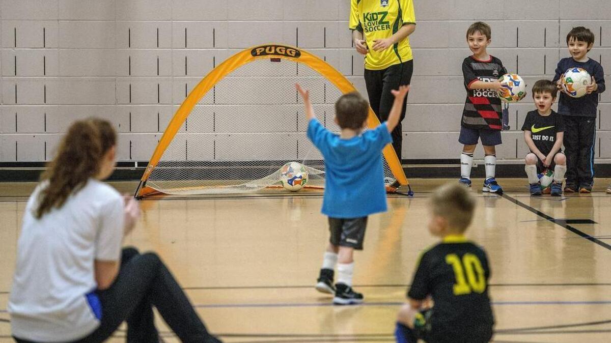 A toddler raises his hands in triumph after kicking a ball into a net Tuesday, March 1, during a “Kidz Love Soccer” program at Drum Intermediate School. Kids soccer programs like this one are the types of activities the proposed UP Metro Park District would take over if voters approve its formation.