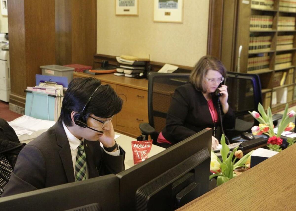 Kento Azegami, left, and Jeanne Blackburn answer phones at the front desk at Gov. Jay Inslee's office in Olympia, Wash., on Thursday, March 1, 2018. Inslee's office has been receiving thousands of emails and phone calls asking him to veto a bill passed hastily by the Washington Legislature last week that would circumvent a recent court ruling that found state lawmakers are fully subject to the state's Public Records Act. (AP Photo/Rachel La Corte)