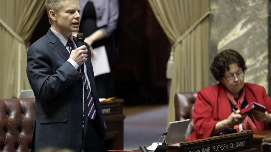 Sen. Jamie Pedersen, left, D-Seattle, speaks during debate on the Senate floor, Thursday, March 8, 2018, at the Capitol in Olympia, Wash., on the final day of the regular session of the Legislature. Lawmakers in the Senate were discussing a compromise measure designed to make it easier to prosecute police who commit reckless or negligent shootings in Washington state. (AP Photo/Ted S. Warren)