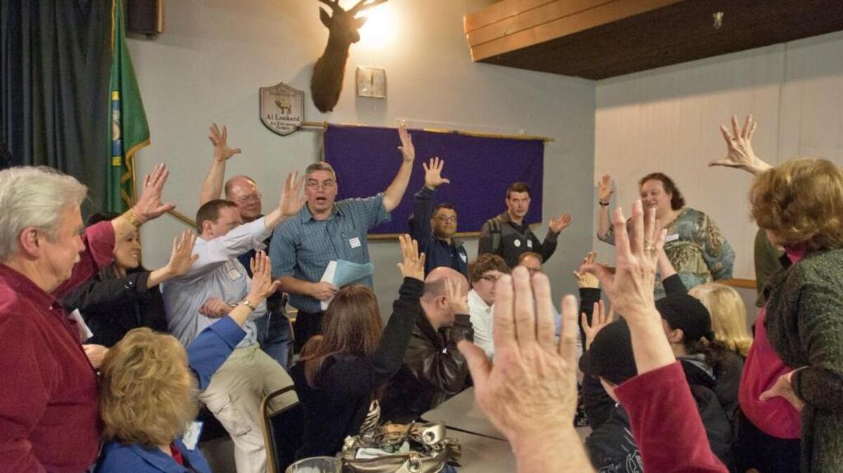 FILE PHOTO: A vote is taken by precinct 168 at a large Republican caucus gathering for all of the precincts in the 25th Legislative District held at the Puyallup Elks Lodge in 2012.
