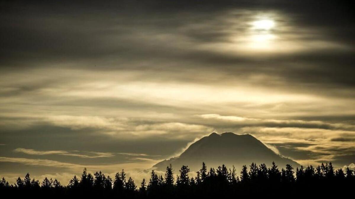 Early morning sun above Mount Rainier seen from Longbranch. Though beautiful, the mountain is seen by scientists as one of the most potentially dangerous volcanoes in the world.
