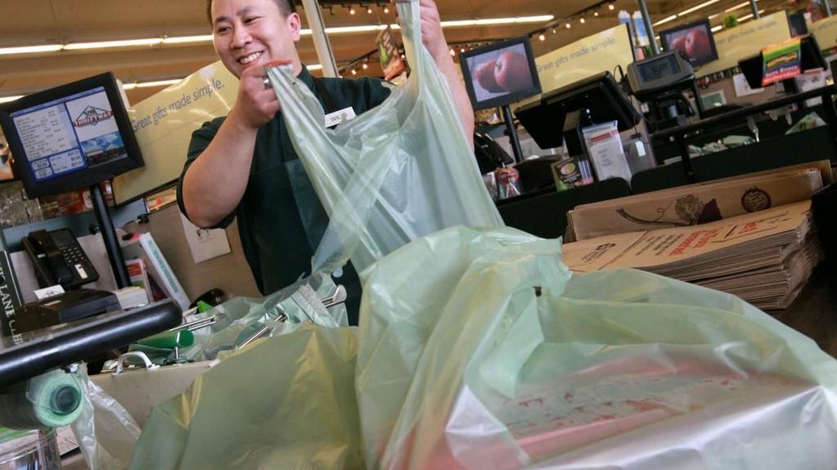 Will Gong bags up groceries for customers at Ralph’s Thriftway in Olympia in 2012.
