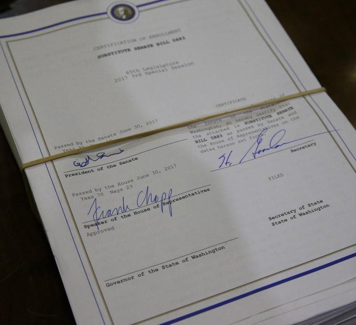 A copy of the new two-year state operating budget awaits the signature of Washington Gov. Jay Inslee before a signing ceremony, Friday, June 30, 2017, at the Capitol in Olympia, Wash. The budget was approved by the Legislature earlier in the day, just in time to avert a partial government shutdown.