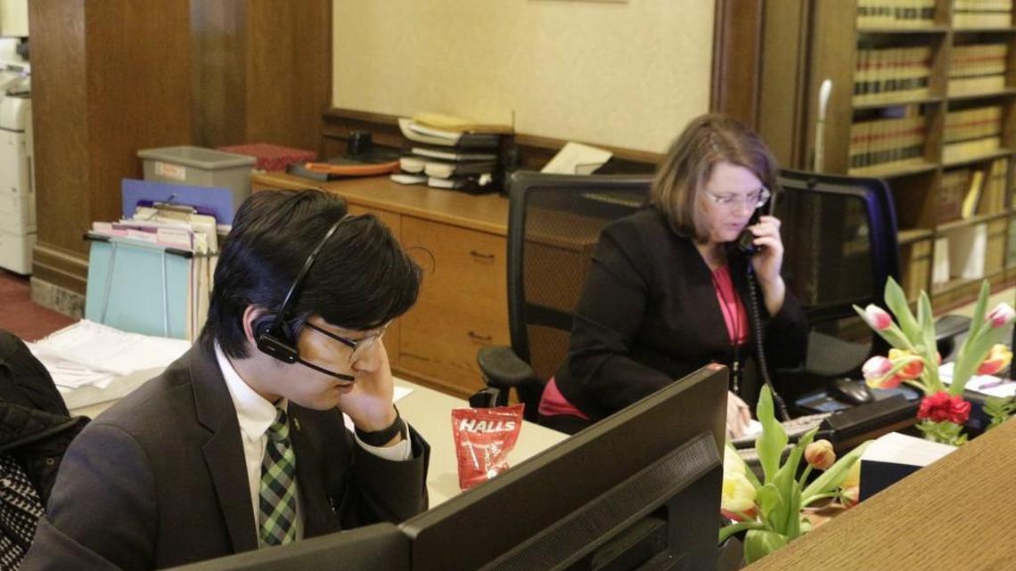 Kento Azegami, left, and Jeanne Blackburn answer phones at the front desk at Gov. Jay Inslee's office in Olympia, Wash., on Thursday, March 1, 2018. Inslee's office has been receiving thousands of emails and phone calls asking him to veto a bill passed hastily by the Washington Legislature last week that would circumvent a recent court ruling that found state lawmakers are fully subject to the state's Public Records Act. (AP Photo/Rachel La Corte)