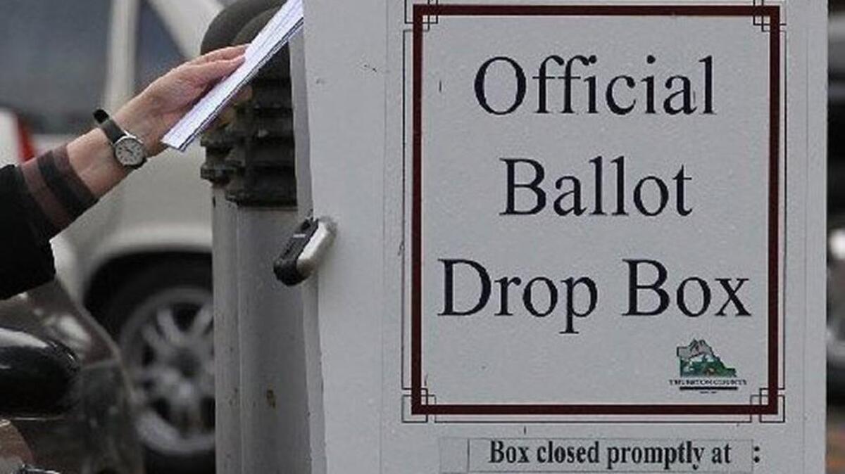 A voter returns a ballot to a drop box at the Thurston County Courthouse in 2015. For Tuesday’s primary election, voters can return their ballots in the mail or by using official drop boxes, which are open until 8 p.m. on Election Day.