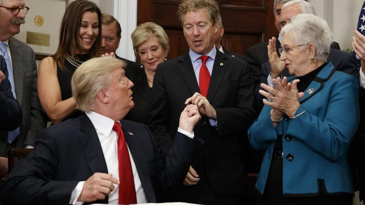 President Donald Trump hands a pen that he used to sign an executive order on health care to Sen. Rand Paul, R-Ky., in the Roosevelt Room of the White House, Thursday, Oct. 12, 2017, in Washington. (AP Photo/Evan Vucci)