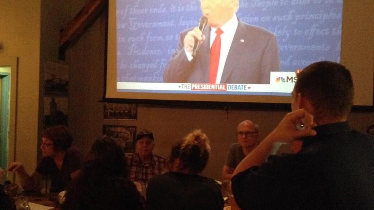 Chris LeBlanc, right facing away, and Wayne Parks, second from right, watch the second 2016 presidential debate between Hillary Clinton and Donald Trump on screen Sunday at the Harmon Tap Room in Tacoma.