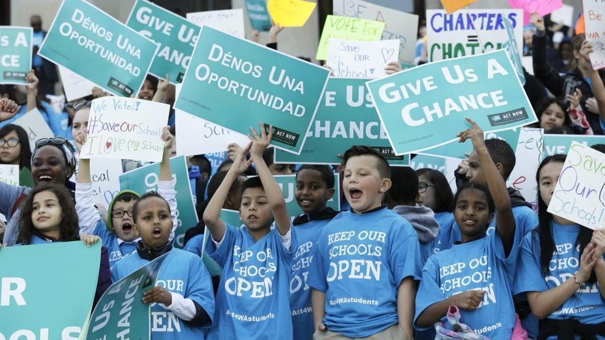 Children hold signs during a February rally in support of public charter schools at the Capitol in Olympia.