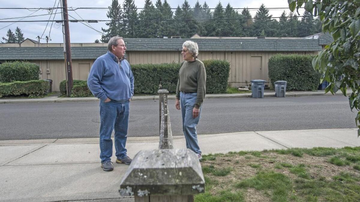Fircrest neighbors Scott Brannon, left, and Ken Porter live across the street from a shopping center that could have restaurants serving liquor by the glass if Proposition 1 passes this fall. They already have complaints about the look of the complex, which they have fought for years to get cleaned up without success. Their biggest issue is their proximity to the complex; their homes are 75 feet across the street and garbage bins sit in plain view during much of the week.