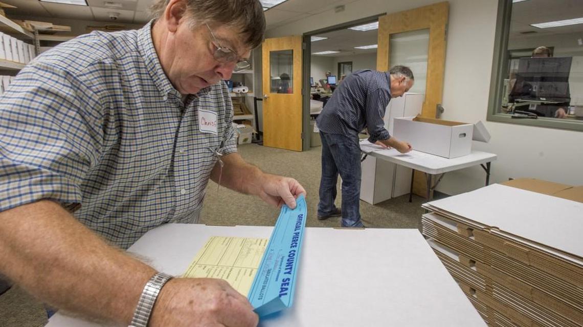 Election workers label and seal boxes of ballots after they were scanned in the tabulation area of the Pierce County Elections Center, Nov. 2, 2015.