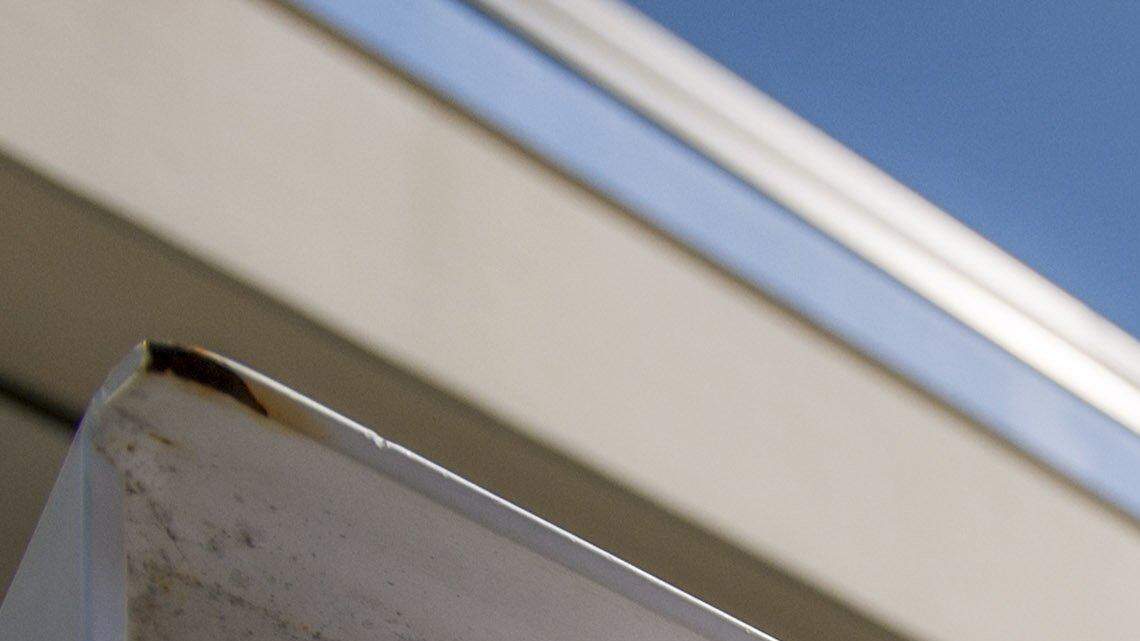 A voter deposits election ballots in the drop box on Monday at the Pierce County Annex.