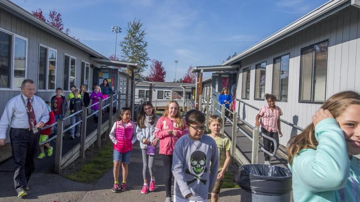 Fourth-graders stream out of portable classrooms Oct. 15 at Zeiger Elementary in South Hill. The school has 11 classes and programs in portables, some of the more than 200 portables the Puyallup School District uses. The bond passing Tuesday night will eliminate the need for 100 portables at the district’s elementary schools.