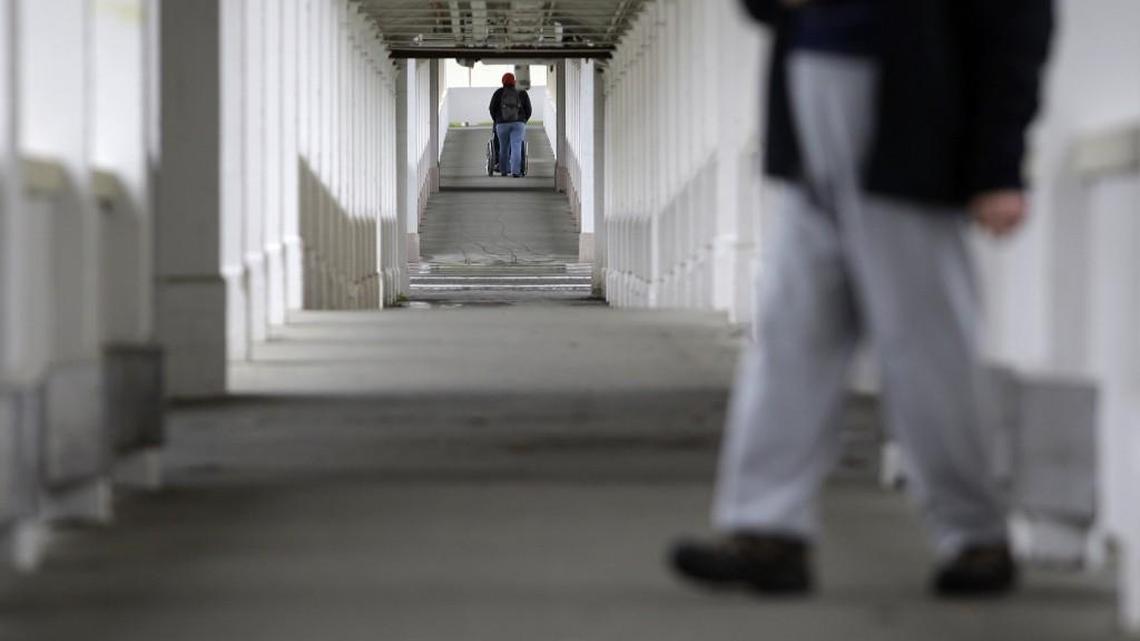 In this Feb. 3, 2010 photo, residents pass through an outside walkway at the Rainier School in Buckley, Washington. A newly filed lawsuit contends the school is “a dangerous place to live.”