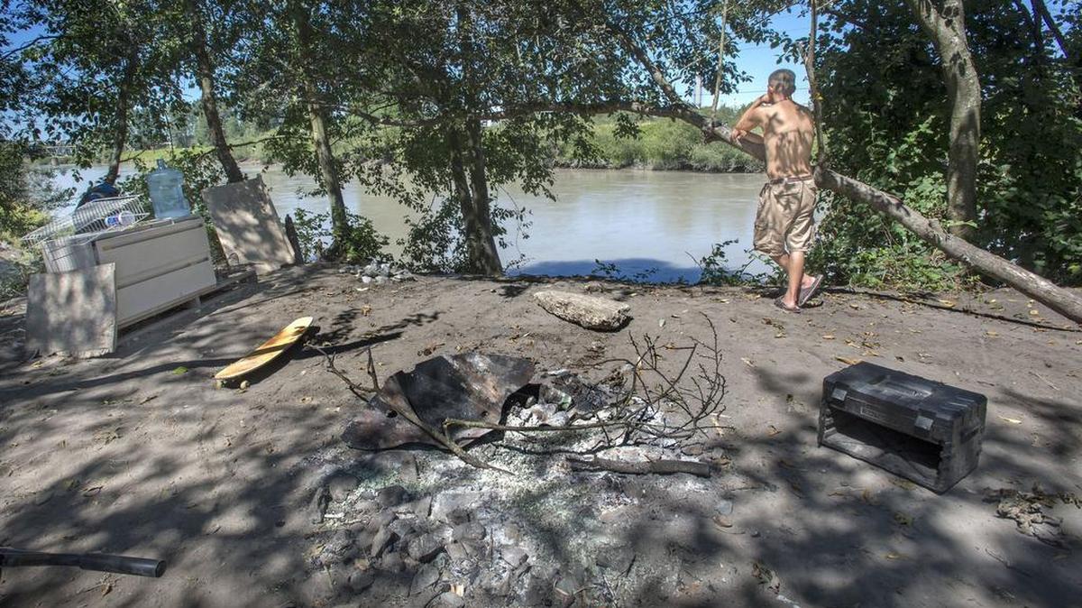 R.J., who didn’t want to give his full name, looks out at the Puyallup River at a camp Monday. R.J. said he doesn’t live by the river full time, but does live there occasionally.