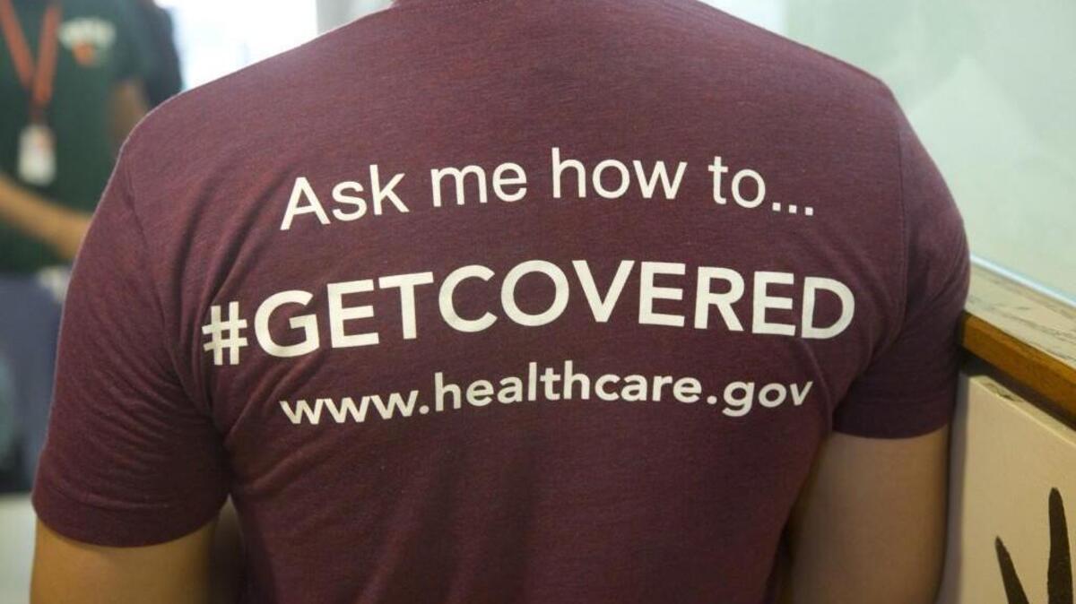 A volunteer health care worker wears a T-shirt, getting people to sign up for the new health care programs, in Miami. The state insurance commissioner has sent a letter to Washington, D.C., with advice for any health care changes.