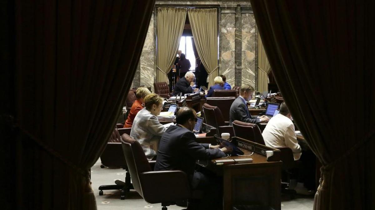 People work on the Senate floor as a session of the Washington Legislature stretches into the evening at the Capitol in Olympia. A citizen commission decided to award lawmakers raises of 2 percent per year each of the next two years.