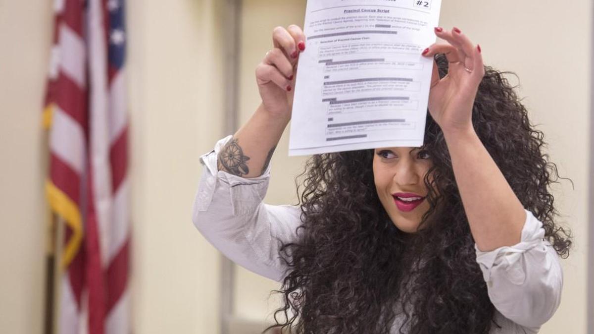 Regional field director Celia Jackson holds a copy of a script that sets the agenda for Washington State Democrats precinct caucuses at a training session at the Federal Way Library on Sunday.