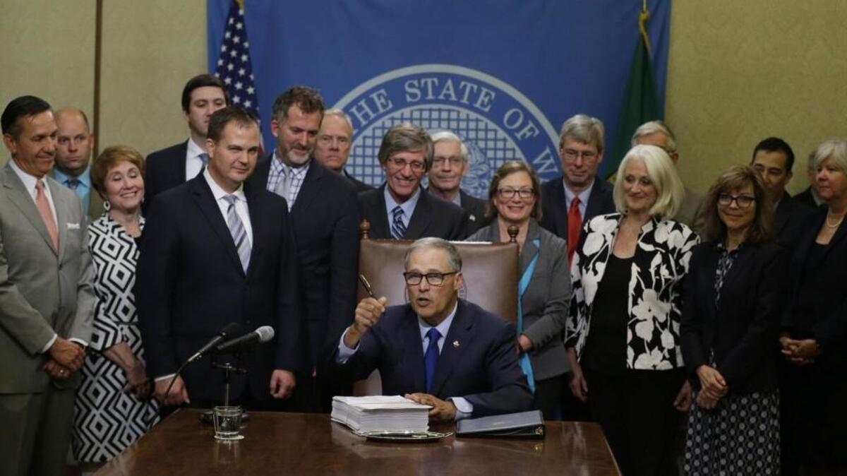 Washington Gov. Jay Inslee holds up his pen after he signed a new two-year state operating budget Friday at the Capitol in Olympia. The budget was approved by the Legislature earlier in the day, just in time to avert a partial government shutdown.