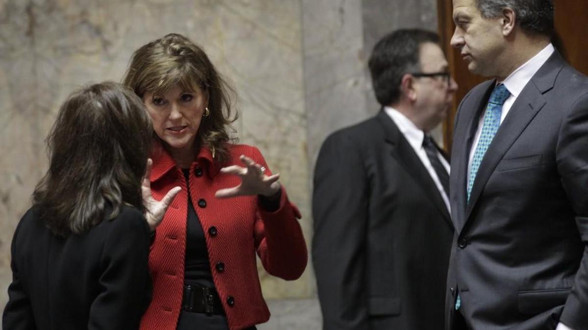 Susan Hutchison, center, chats in the Senate Chambers during the 2015 legislative session in Olympia. Hutchison announced Tuesday that she would be resigning as chairman of the state Republican Party next month.