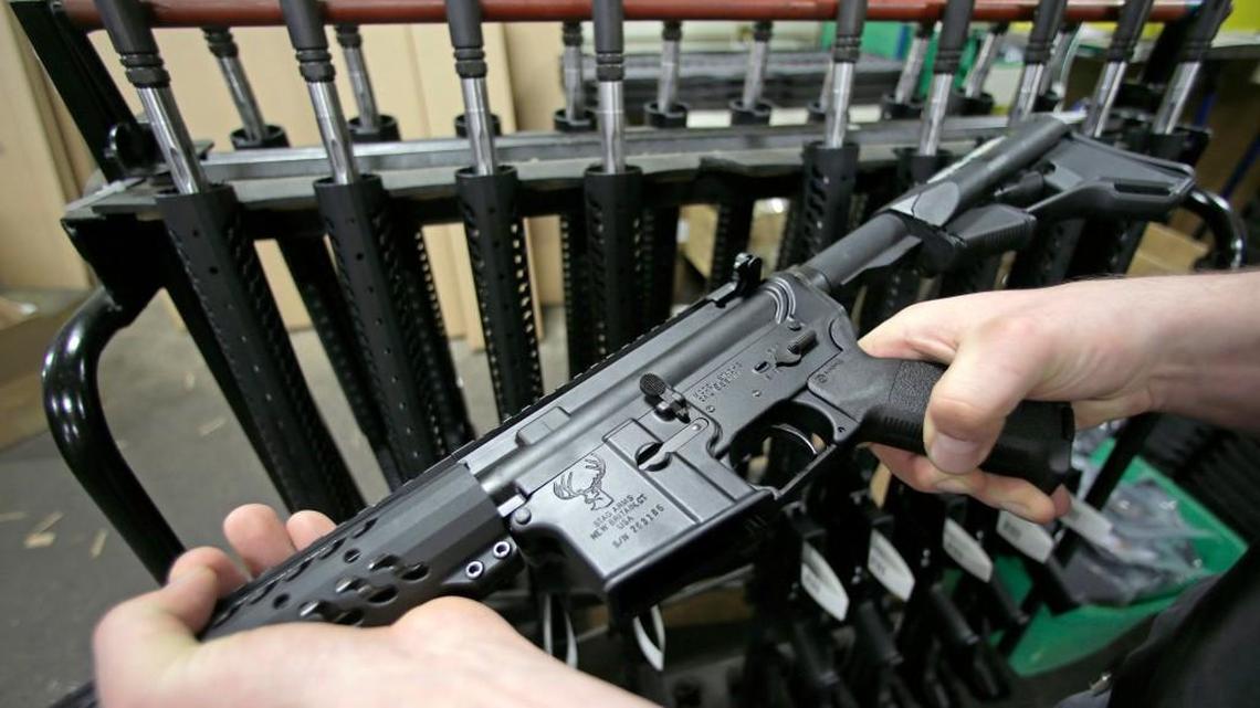 FILE - In this April 10, 2013 file photo, craftsman Veetek Witkowski holds a newly assembled AR-15 rifle at the Stag Arms company in New Britain, Conn. (AP Photo/Charles Krupa, File)