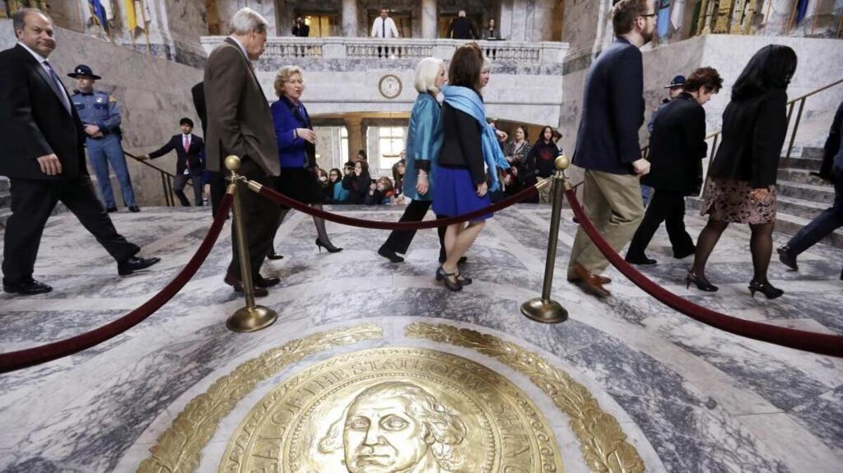 In this March 18, 2015, file photo, senators walk through the rotunda and toward the House Chamber to a joint session of the Washington state Legislature, in Olympia, Wash. During their last two budget-writing cycles, Washington lawmakers extended their 105-day sessions to last more than six months. Some lawmakers say those overtime sessions — along with lawmakers’ relatively low pay — make it difficult for everyday citizens to serve as legislators.
