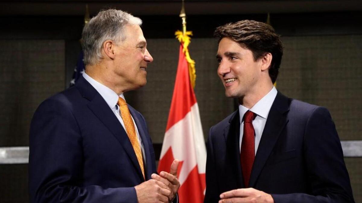 Canada Prime Minister Justin Trudeau, right, and Washington Gov. Jay Inslee chat as they pose for photographers before a meeting Thursday in Seattle. The two were to discuss trade, regional economic development, and climate.