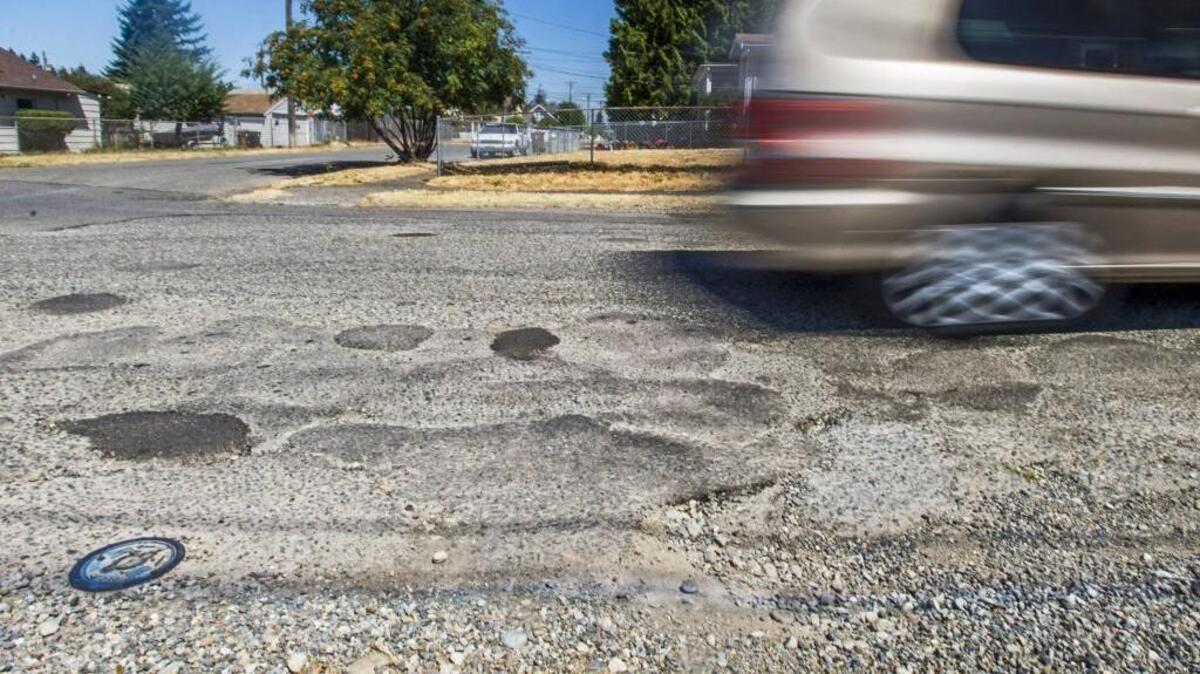 An assortment of patches and potholes on a residential street in Tacoma’s Oakland neighborhood, June 30, 2015.
