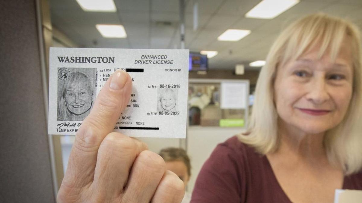 Michelle Henrich shows off a temporary enhanced drivers license she just received at the state licensing office in Tacoma on Tuesday, Aug. 16, 2016. A pen was used to black out sensitive information.