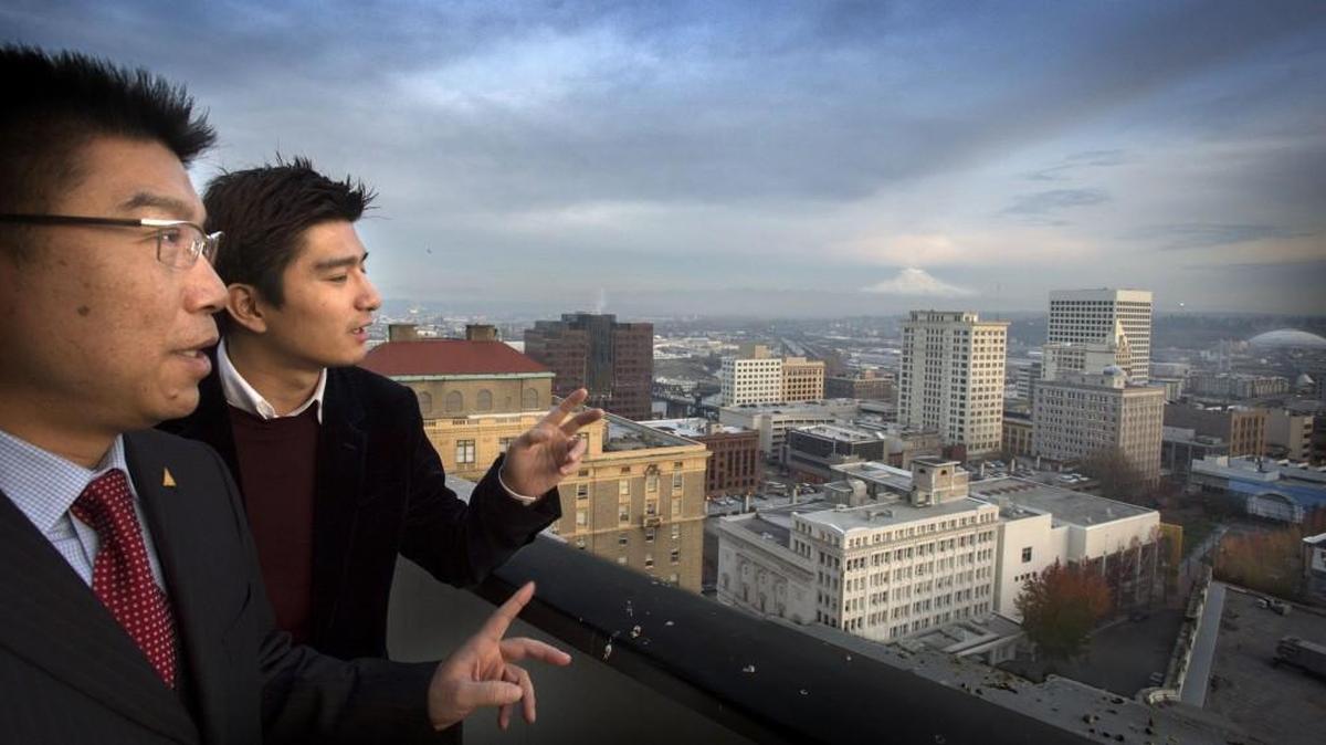 Chun Yang and his son, Yiwen, looked at the Tacoma skyline for a proposed hotel in downtown Tacoma in November 2014. Mayor Marilyn Strickland will check in with Yang during an upcoming trade mission to Asia.