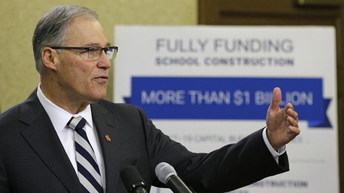 Washington Gov. Jay Inslee talks to reporters, Thursday, Dec. 14, 2017, after unveiling his supplemental budget proposal at the Capitol in Olympia, Wash. Inslee proposed tapping the state's reserves to meet a final timeline required for Washington state to comply with a state Supreme Court mandate on education funding, and said he wants a new tax on carbon emissions from fossil fuels to ultimately backfill that withdrawal. (AP Photo/Ted S. Warren)