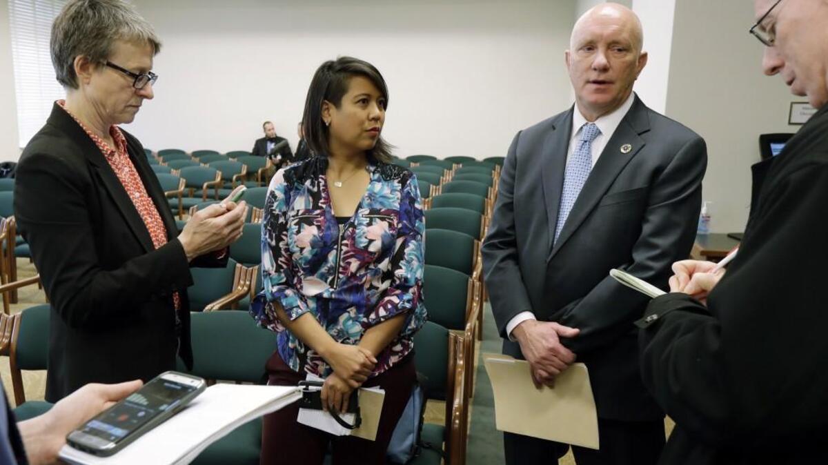 Steven Strachan, third from left, executive director of the Washington Association of Sheriffs and Police Chiefs, talks to reporters along with Leslie Cushman, left, and Heather Villanueva, second from left, both of De-Escalate Washington, Tuesday, March 6, 2018, in Olympia, Wash., following a House hearing on the use of deadly force by law enforcement officers. (AP Photo/Ted S. Warren)