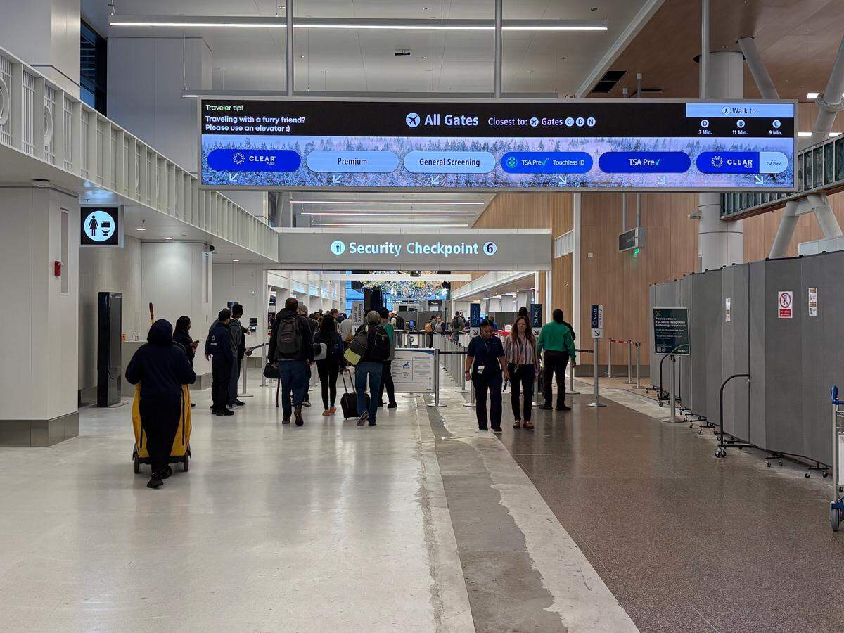 Travelers are shown at Seattle-Tacoma International Airport.