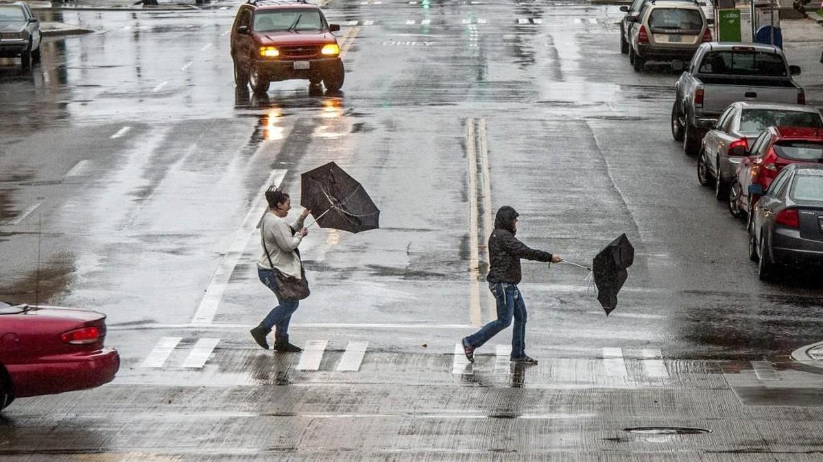 Wind gusts and steady rain make a challenge to pedestrians with umbrellas in downtown Tacoma, November 17, 2015.