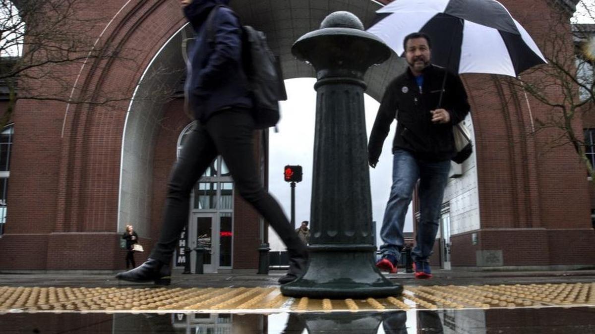 Dodging raindrops and puddles was in vogue and a matter of necessity as commuters hopping off the Link Light rail in front of the Washington State History Museum scurried to shelter Tuesday.