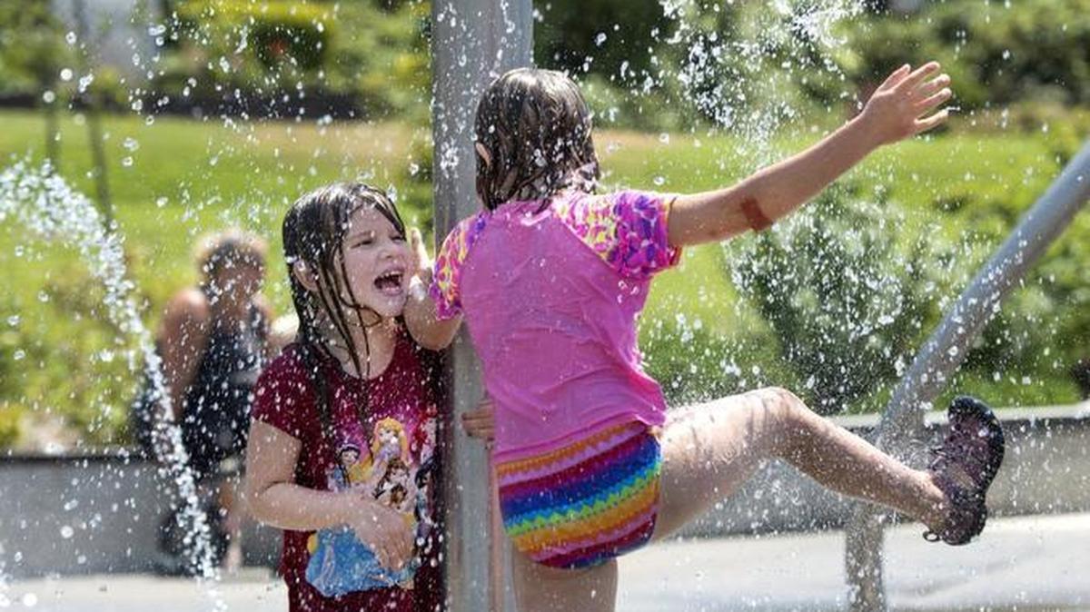 Record-high temperatures are predicted later this week so area pools and spray parks should be busy. "It's almost like an umbrella that we don't have to hold," said Lainey Griffin, 6, of a water feature she enjoyed cavorting under with her best buddy Cady Young, 7, at the Titlow Park sprayground in Tacoma. File photo shot July 6, 2015.