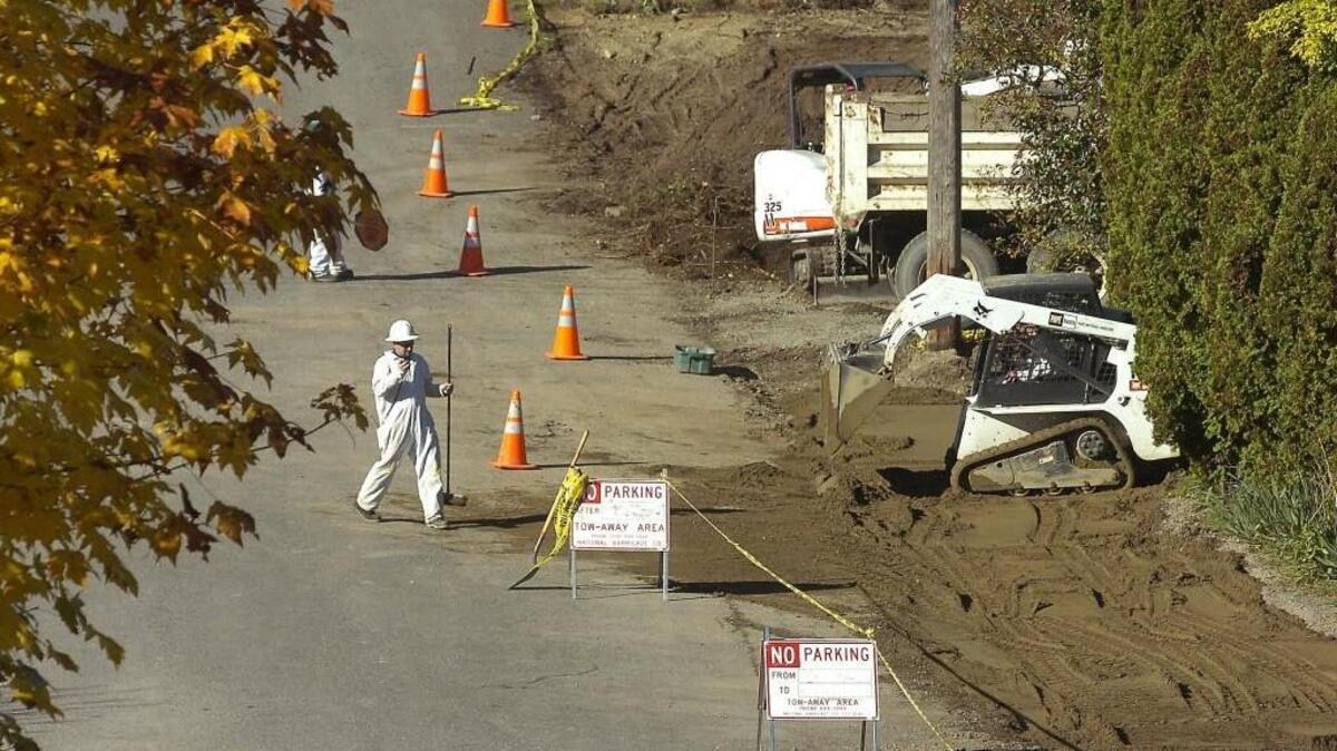 A worker with MRC Construction helps backfill clean soil (lower right) after contaminated soil was removed from a property in the Asarco plume zone on 48th Street in Ruston.