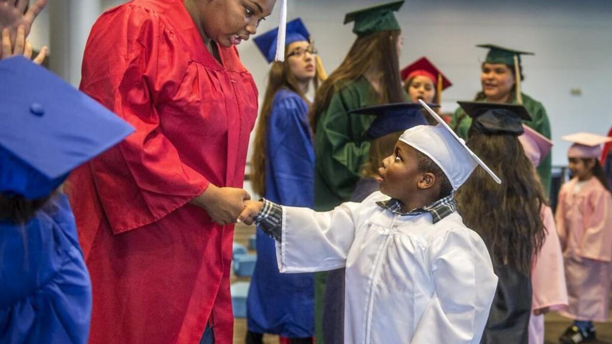 Whitman Elementary School kindergartener Cavali Davis, class of 2029, right, gives his undivided attention to Mount Tahoma High School class of 2020 member Aniya Critton as they shake hands after making a graduation pact during the the semi-annual Graduate Tacoma event last year.