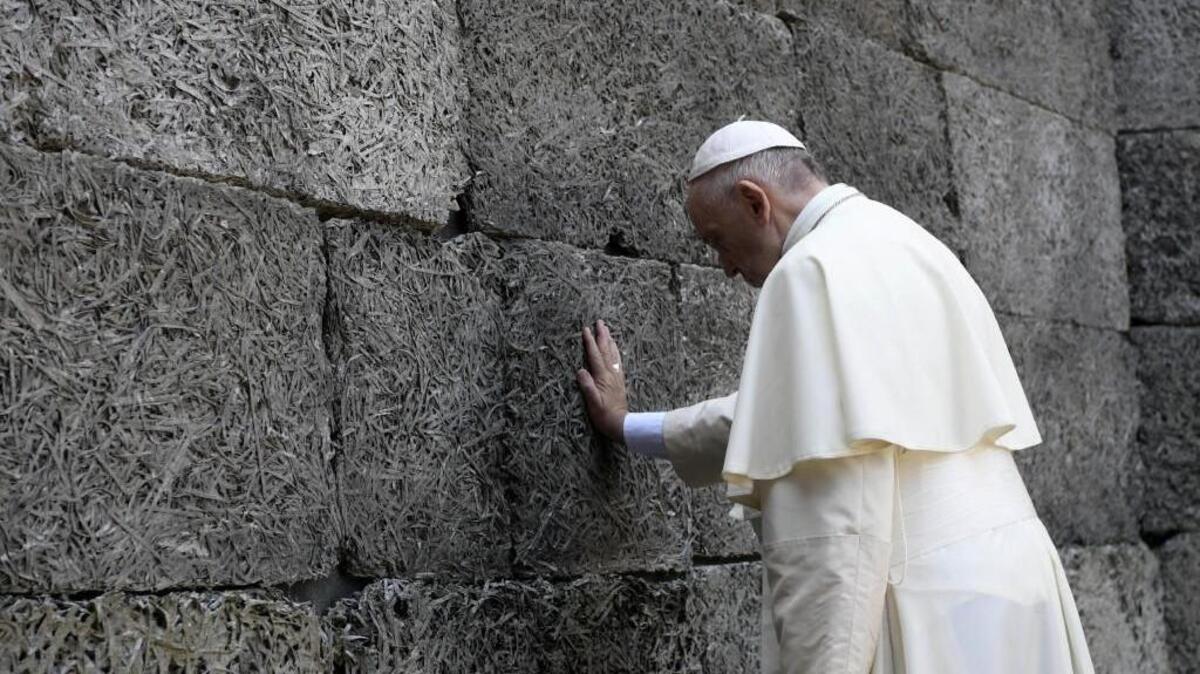Pope Francis prays in front of the death wall at the former Nazi concentration camp of Auschwitz in Oswiecim, Poland, Friday. He paid a somber visit to the Nazi German death camp of Auschwitz-Birkenau Friday, becoming the third consecutive pontiff to make the pilgrimage to the place where Adolf Hitler's forces killed more than 1 million people, most of them Jews.
