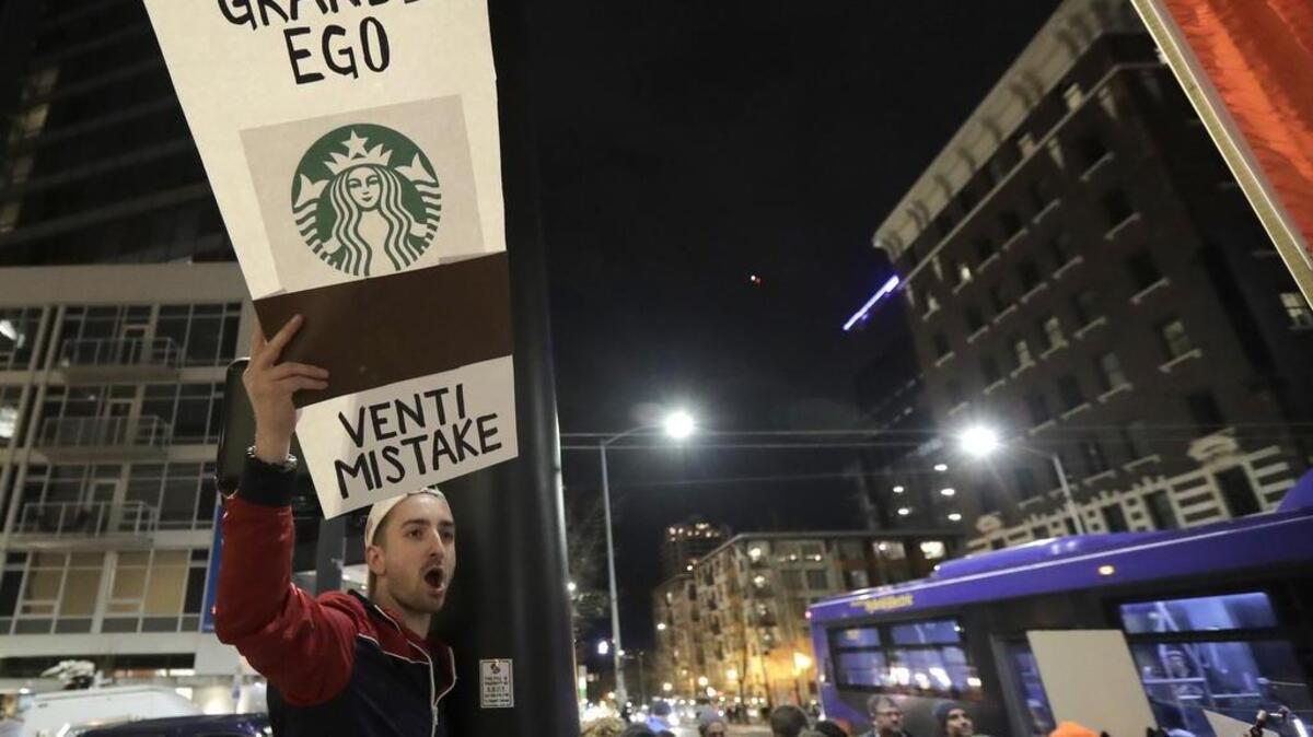 David Schwartz of Bellevue protests outside a book-promotion event held by former Starbucks CEO Howard Schultz Thursday in Seattle.