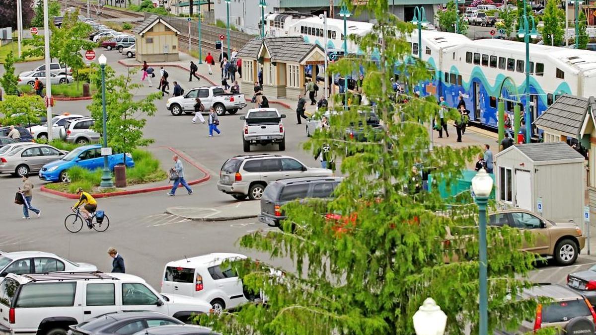 A wave of commuters stride to their vehicles at the Sounder Station in Puyallup.