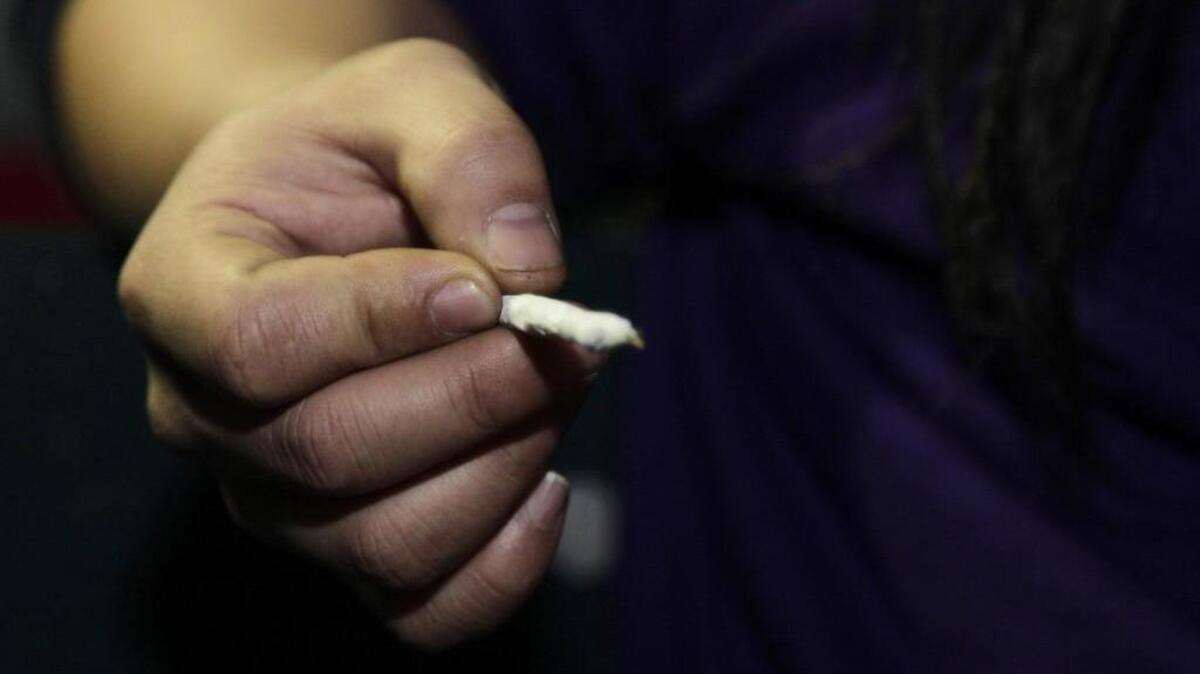 A person holds a freshly-rolled marijuana joint during a late night celebration outside the Space Needle in Seattle.
